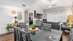 A modern living room with a glass dining table, grey sofas, and a ceiling fan. -  NEW & GORGEOUS Lakefront ZEN 3 bedrooms [2 KING +1 Queen] (Phoenix)