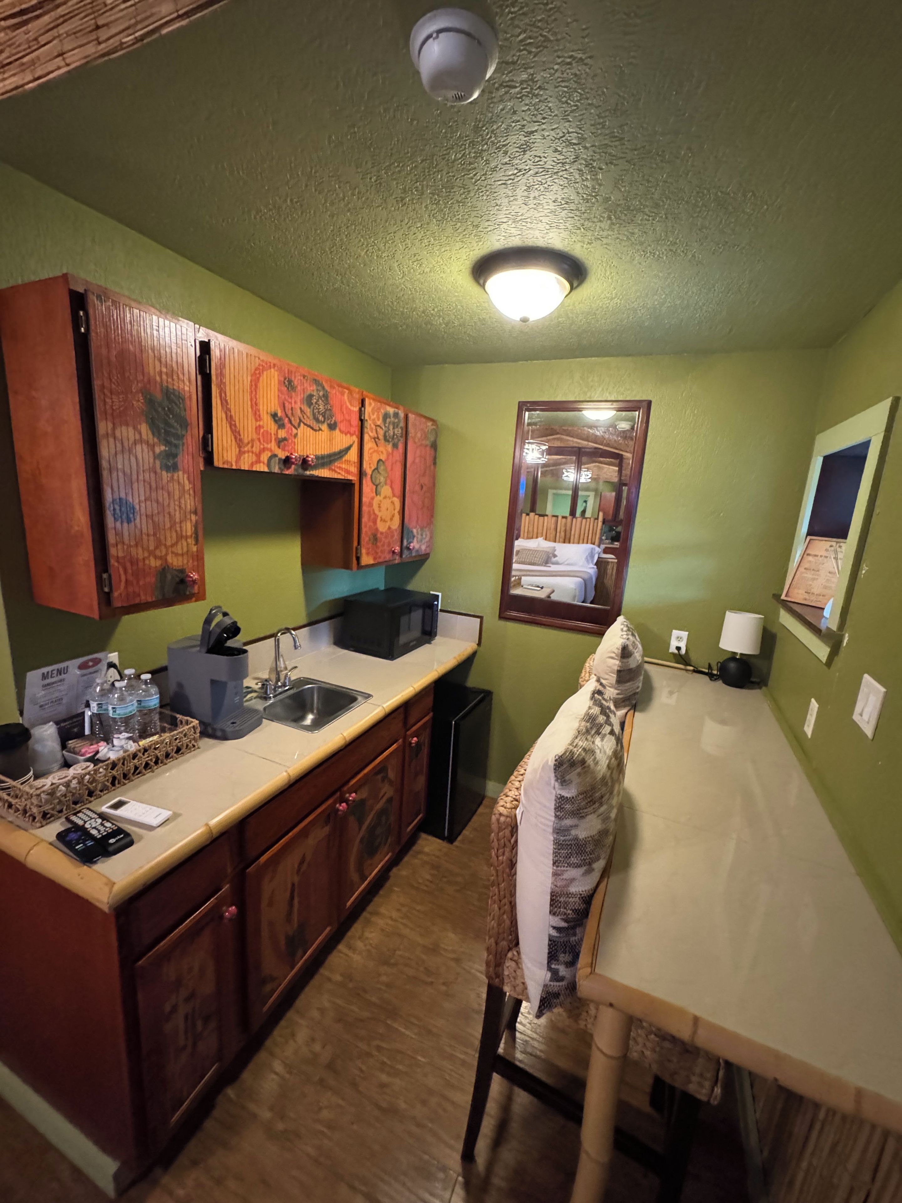 A compact kitchen with a sink, microwave, and wooden cabinets.