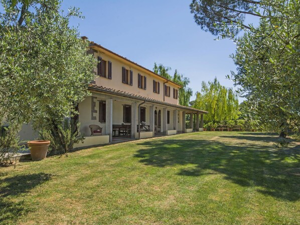 A two-story building with a covered patio area and a lawn in front.