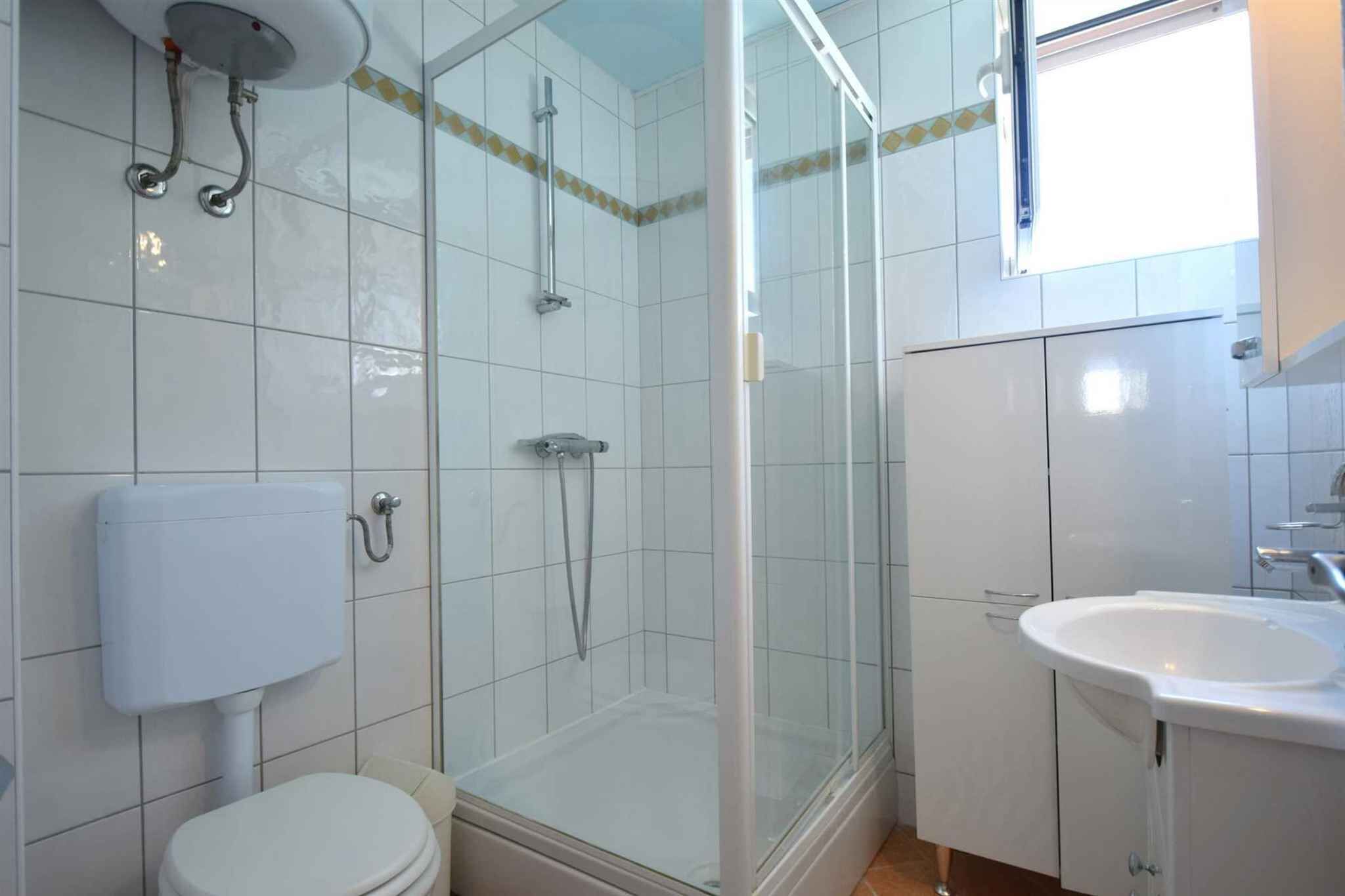 Une salle de bain comprenant des toilettes, un espace douche et un lavabo.