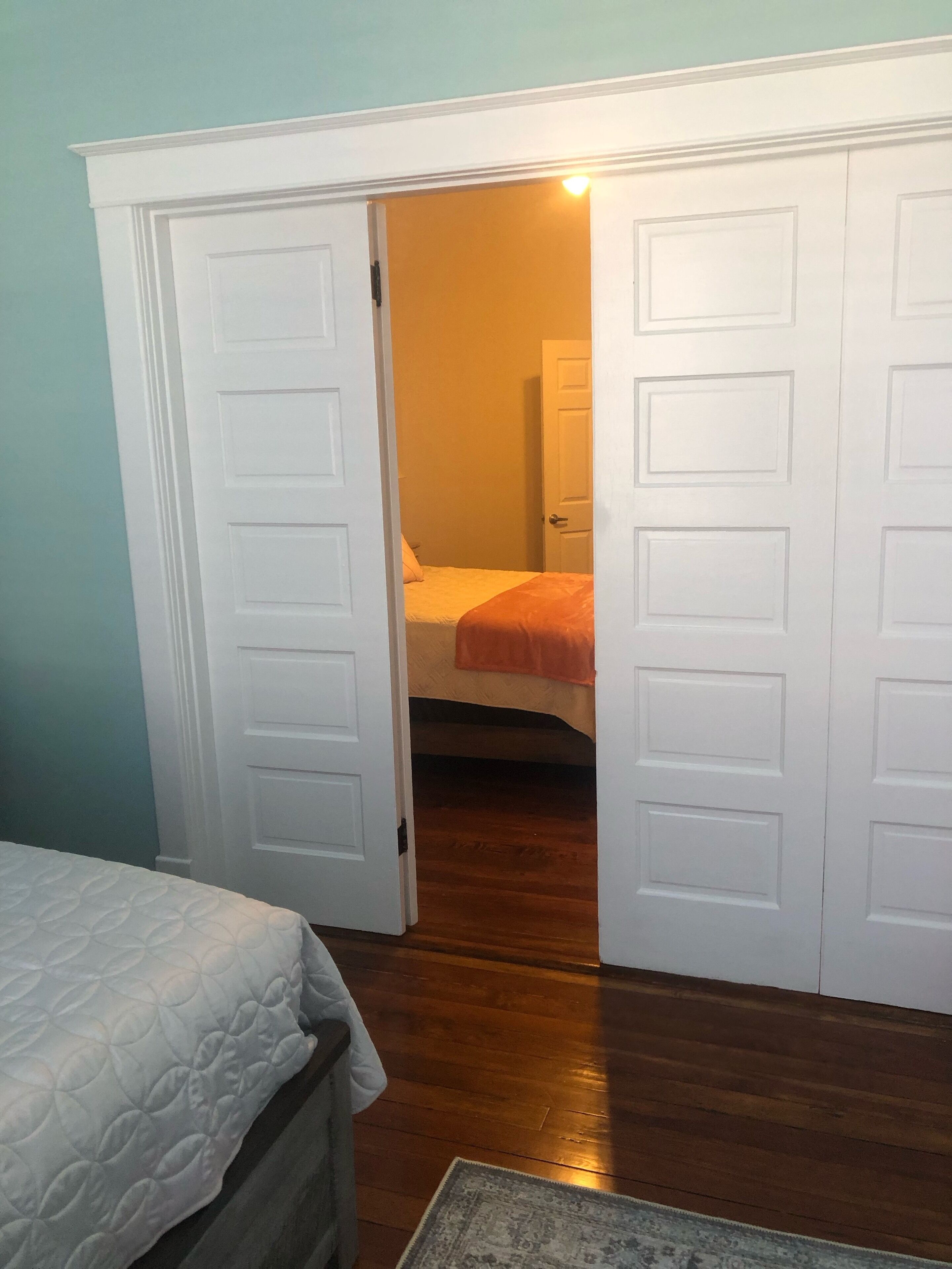 A bedroom with a bed, a nightstand, a dresser, and a closet with sliding doors.