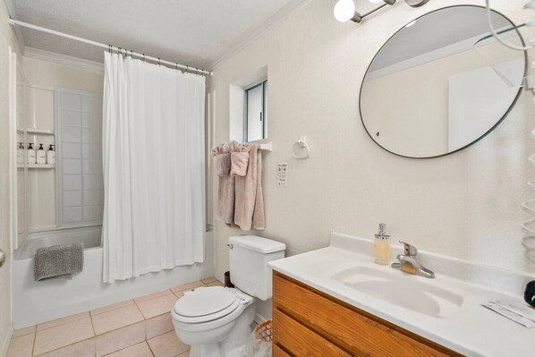 A bathroom with a toilet, sink, and shower area.