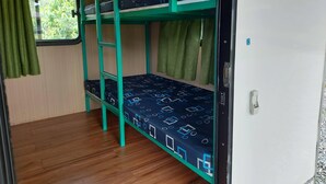 A bunk bed room with a window and curtains, wooden flooring, and a door with a handle. - caravan trailer (New Taipei City)
