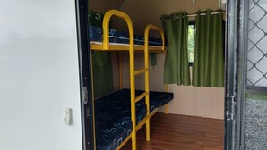 A bunk bed room with a wooden floor, green curtains, and a window with a mesh screen. - caravan trailer (New Taipei City)