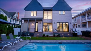 A two-story house with a swimming pool, a covered patio, and a well-maintained lawn. - Rehoboth Beach Ocean Block Private Pool Parking Clean (Rehoboth Beach)