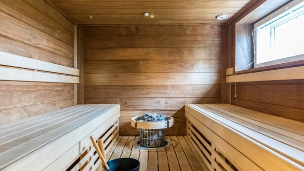 Un sauna avec des bancs en bois et un système de chauffage central.