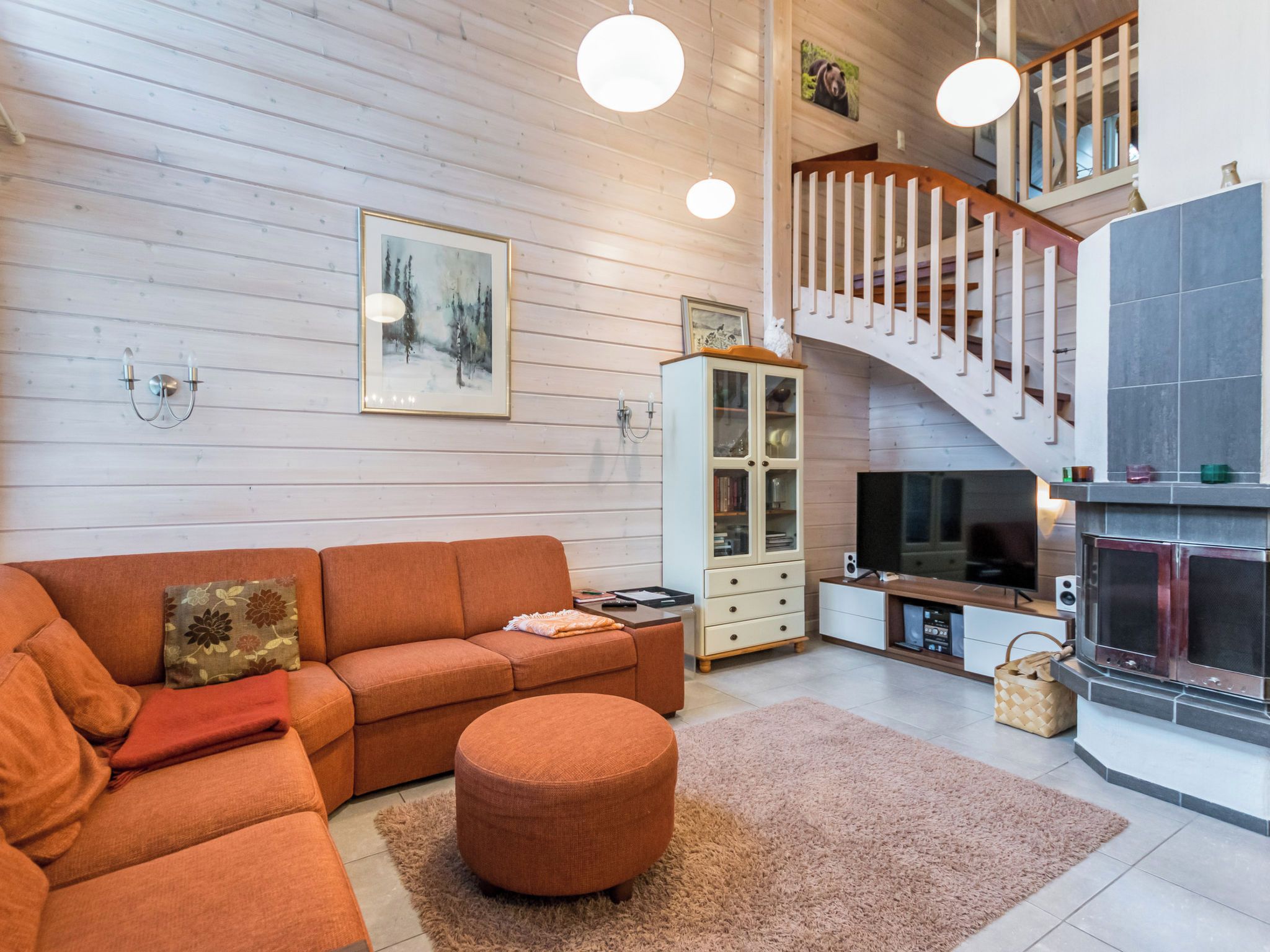 Un salon moderne avec un canapé, un pouf et une cheminée.