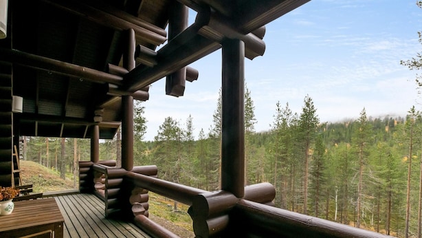 Une terrasse en bois avec vue sur une forêt.