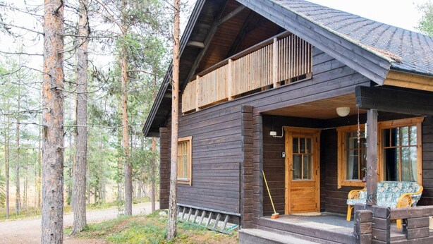 Une cabane en bois avec une véranda, une fenêtre et une porte.
