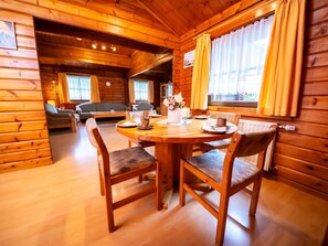 Cozy cabin interior with a dining area for four, featuring a round table and comfortable seating.