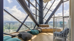 A high-rise interior with a panoramic city view, modern seating, and a wooden floor. - Continew Residensi by Airhost  (Kuala Lumpur)