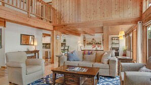 A spacious living room with a high ceiling, wooden beams, a sofa, armchairs, and a coffee table. - Private Hot Tub _ Pet Friendly _ 2 Living Rooms + Kitchen & Kitchenette (Vail)