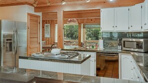 A modern kitchen with white cabinets, stainless steel appliances, and a large island. - Private Hot Tub _ Pet Friendly _ 2 Living Rooms + Kitchen & Kitchenette (Vail)