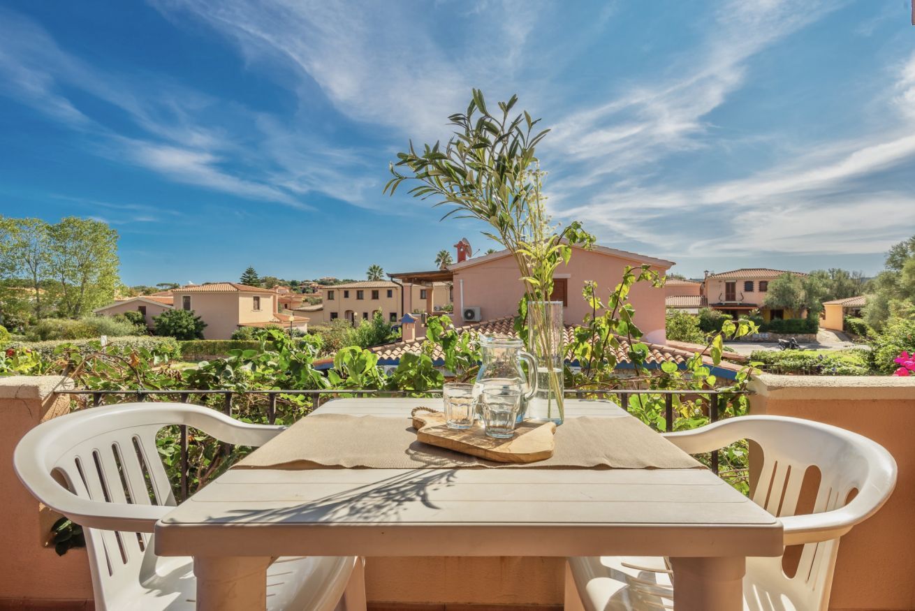 A table set outdoors with a view of a residential area, including houses and greenery.