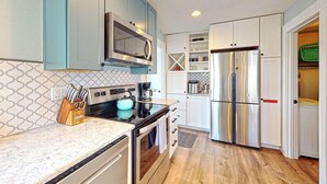 Una cocina moderna con electrodomésticos de acero inoxidable, un microondas y una cafetera.