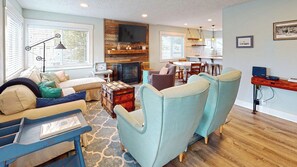 A cozy living room with a fireplace, comfortable seating, and a dining area. - COASTAL COTTAGE at Seaside Beach - Pet Friendly - New Listing!! (Seaside)