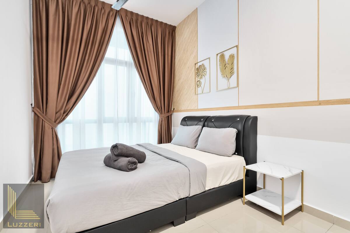 Une chambre d’hôtel moderne avec un lit, des rideaux, une table de chevet et des œuvres d’art murales.