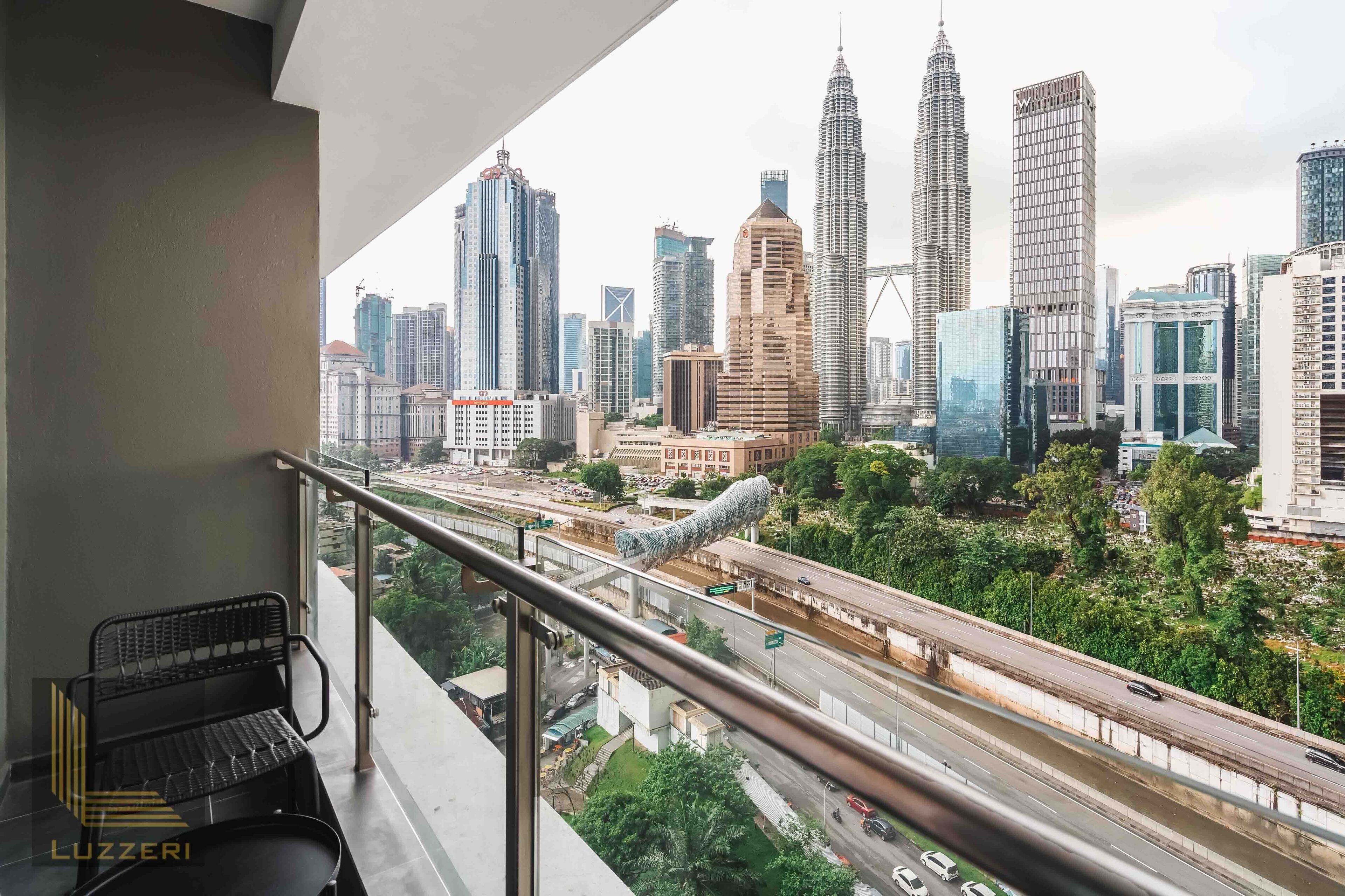 A balcony with a view of a cityscape including the Petronas Towers.