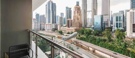 A balcony with a view of a cityscape including the Petronas Towers.