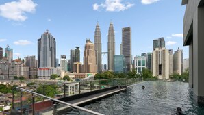 A rooftop pool with a city skyline in the background. - Legasi Kampung Bharu Guesthouse (Kuala Lumpur)