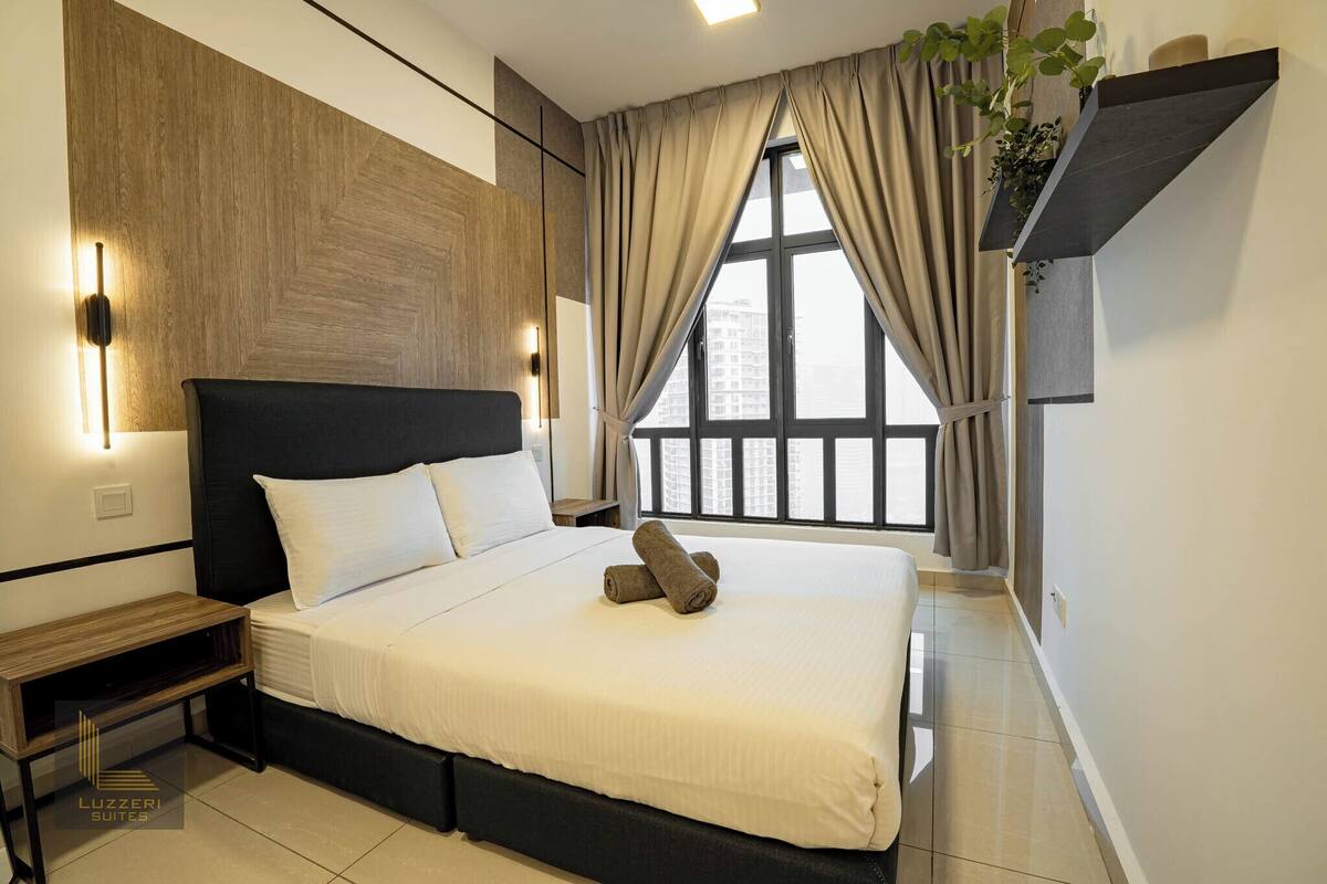 Une chambre d’hôtel moderne avec un grand lit, un mur lambrissé en bois et une fenêtre avec des rideaux.