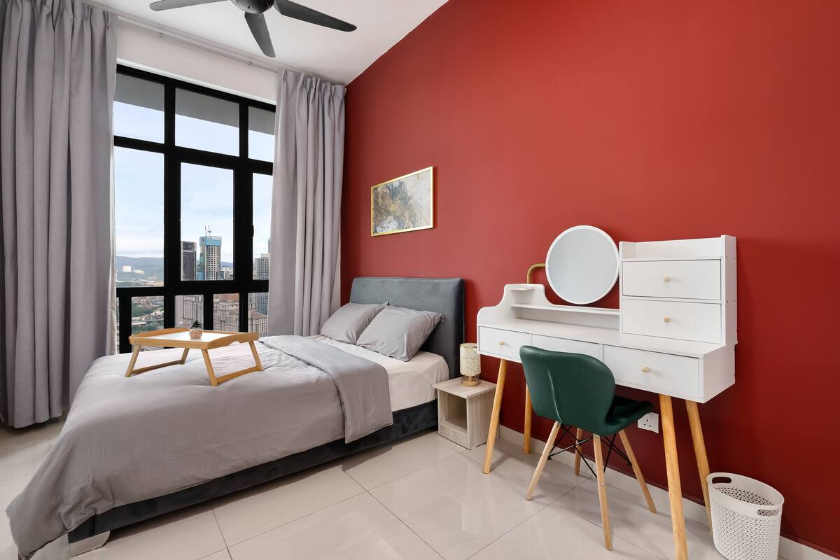 Une chambre moderne avec un lit, un bureau, une chaise, une fenêtre avec des rideaux et une vue sur la ville.