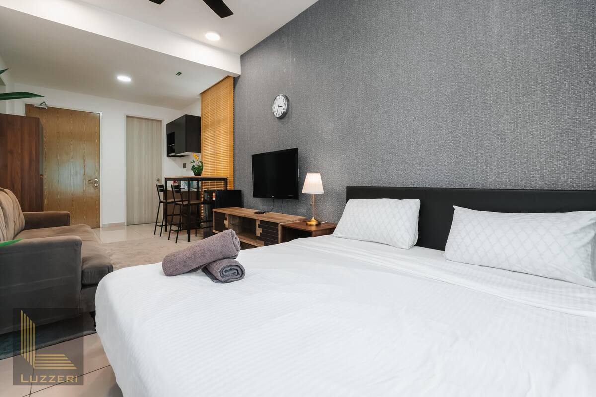 Une chambre d’hôtel avec un lit, un bureau, une télévision et une chaise.