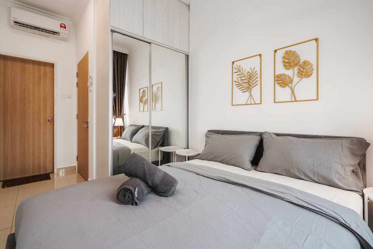 Une chambre d’hôtel avec un lit, une armoire, un miroir et des œuvres d’art accrochées au mur.