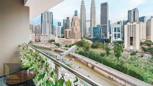 A cityscape view from a balcony with a modern building and a distinctive bridge. - Legasi Kampung Bharu Guesthouse (Kuala Lumpur)