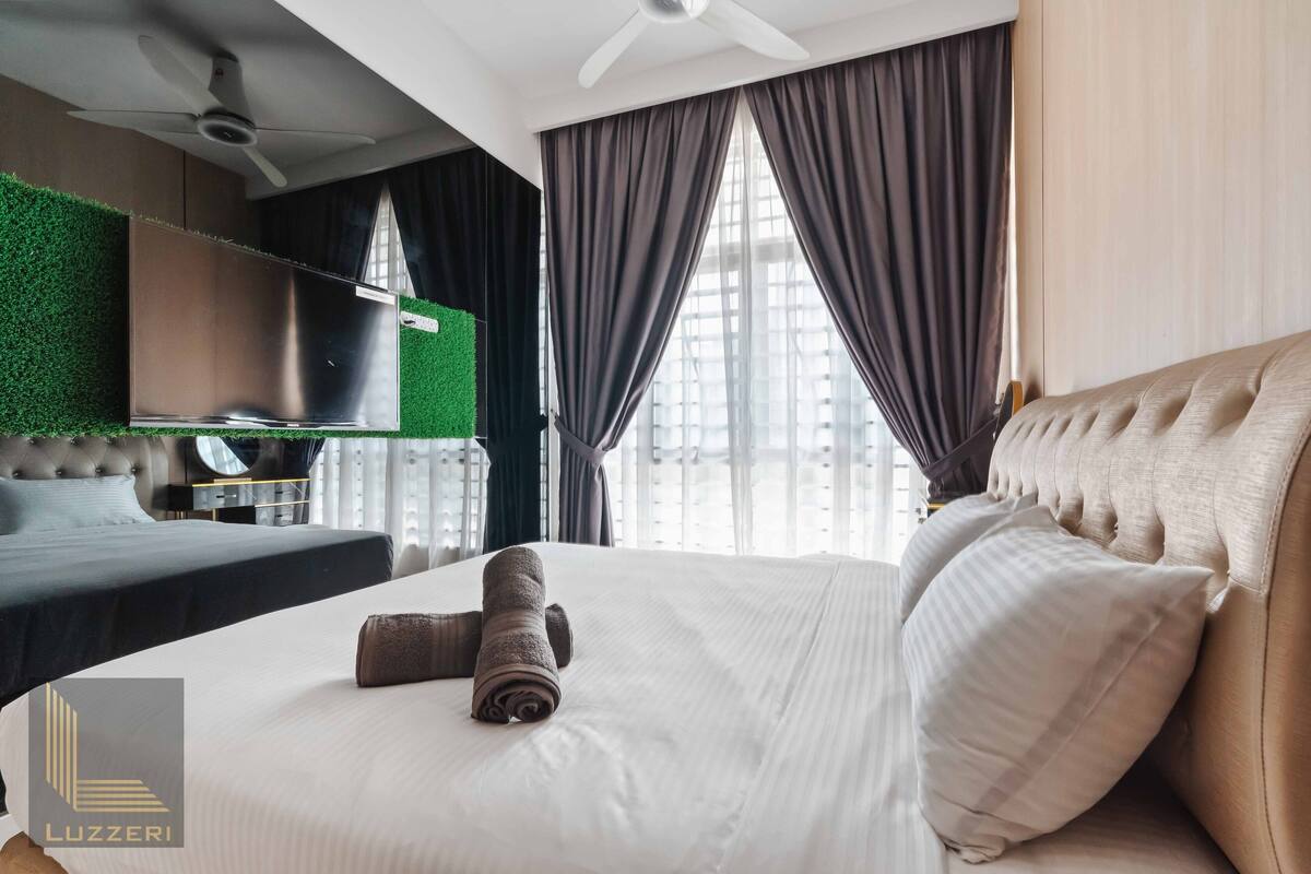 Une chambre d’hôtel moderne dotée d’un grand lit, d’un téléviseur à écran plat et d’un mur végétal.