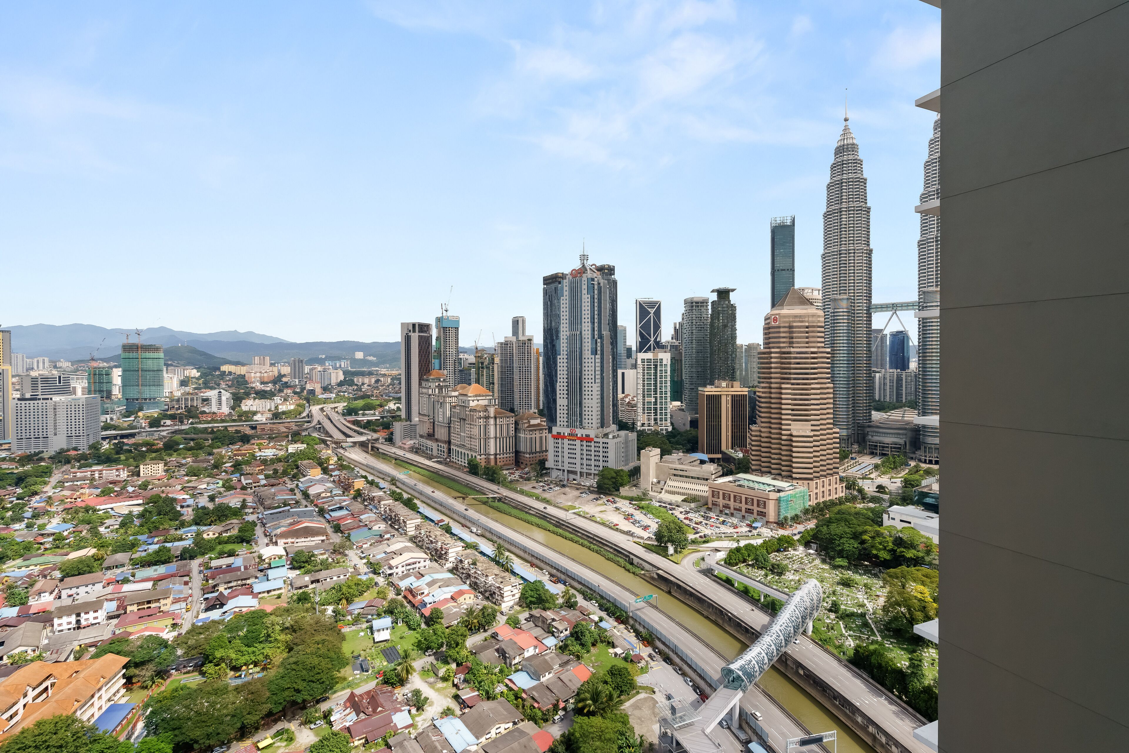 A cityscape with high-rise buildings, a river, and a bridge.