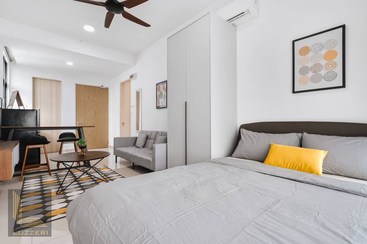 Une chambre à coucher moderne avec un grand lit, un canapé, un bureau et un ventilateur de plafond.