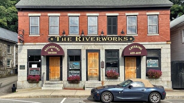 A brick building with a sign reading "The Riverworks" and a car parked in front. - Cozy Newmarket Escape! Wine & WiFi! Full Kitchen! (Newmarket)