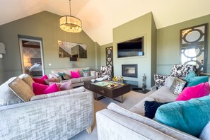 A modern living room with a sectional sofa, a coffee table, and a flat-screen TV.