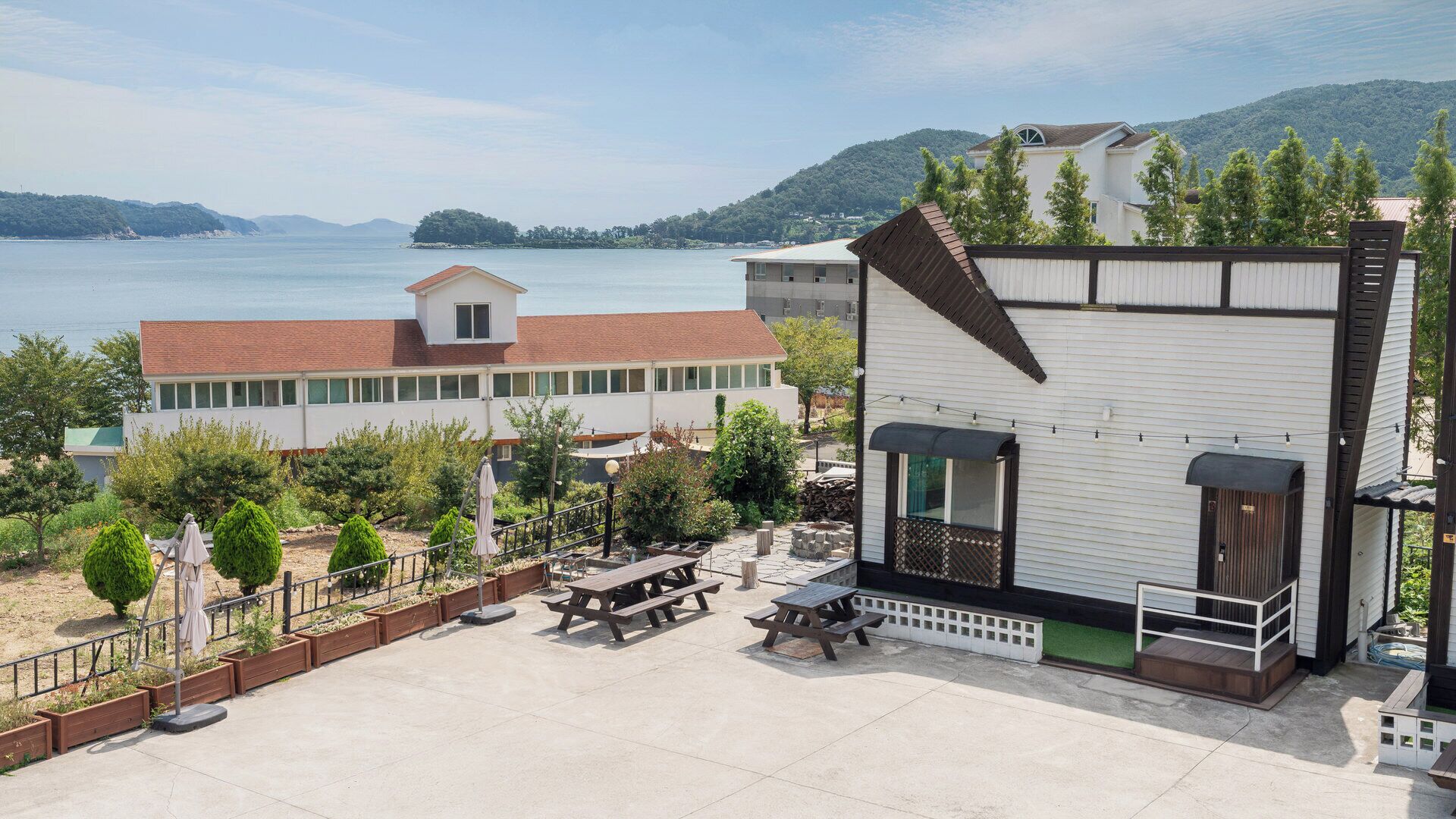 A building with a balcony overlooking a body of water and hills.
