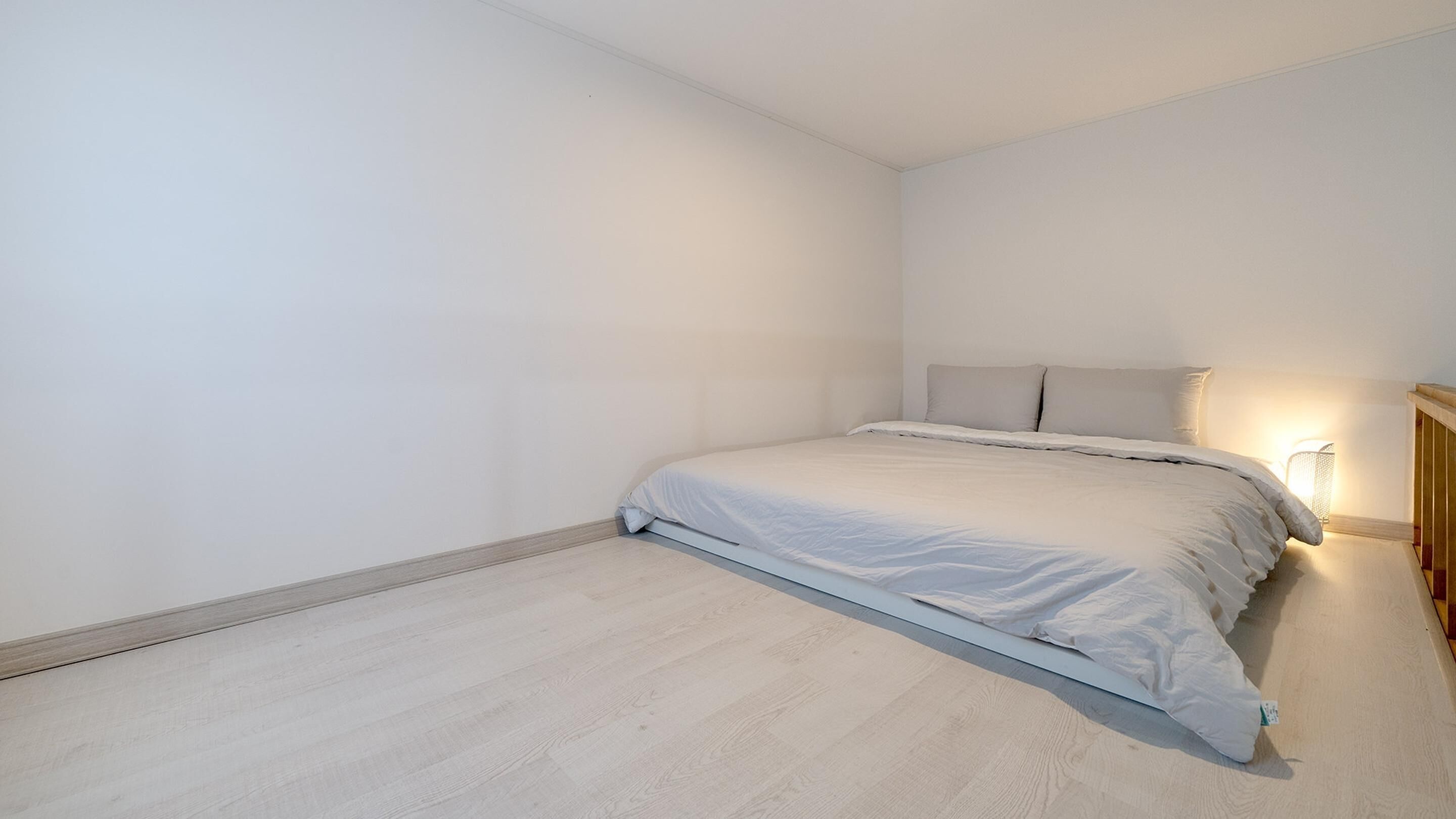 Une chambre à coucher avec un lit, une table de chevet et une lampe.