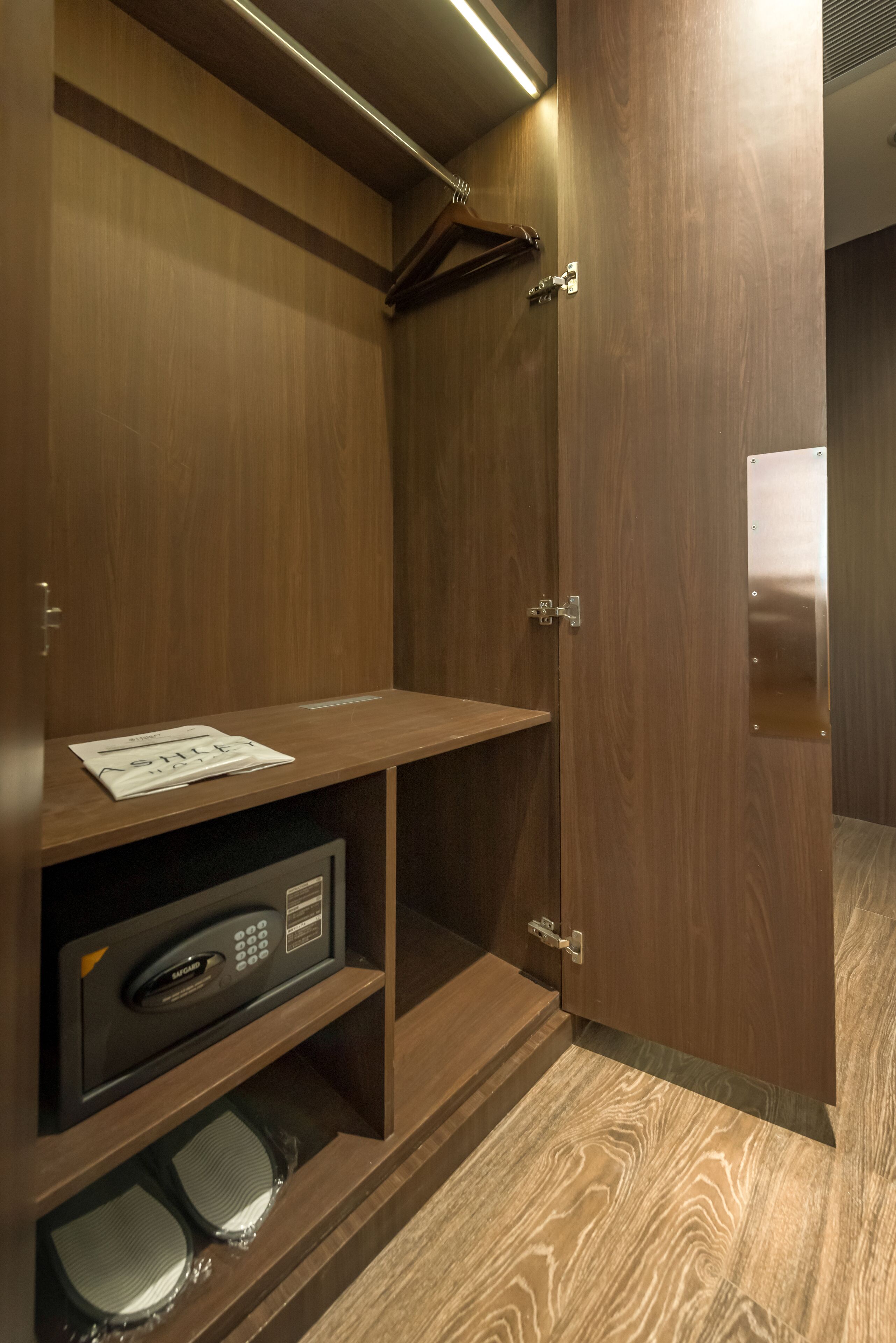 A wooden wardrobe with a built-in microwave and a shelf.