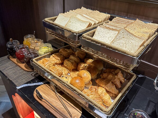 A breakfast buffet with bread, pastries, and jams. - Ashley Tang Menteng Jakarta (Jakarta)