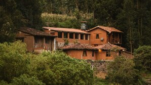 Ein rustikales Haus mit Ziegeldach, umgeben von dichtem Wald.