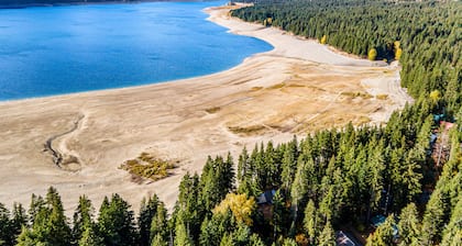 Dog-friendly lakefront home surrounded by trees with wood stove, deck & firepit