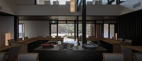 Un comedor moderno con una isla central, mesas y sillas de madera.
