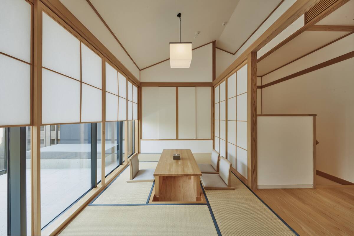 A traditional Japanese room with tatami flooring, a low wooden table, and sliding doors.