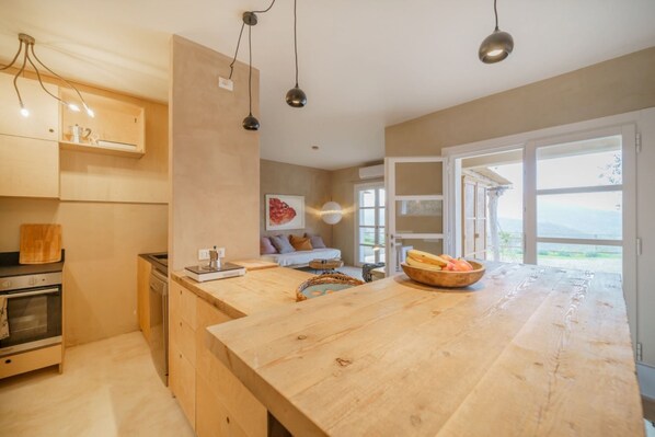 A modern kitchen with wooden cabinets, a large island, and pendant lighting.
