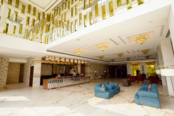 A spacious lobby with a high ceiling, marble flooring, and a reception area with a counter and seating. - Kay-Em Spectra Hotel Chennai (Chennai)