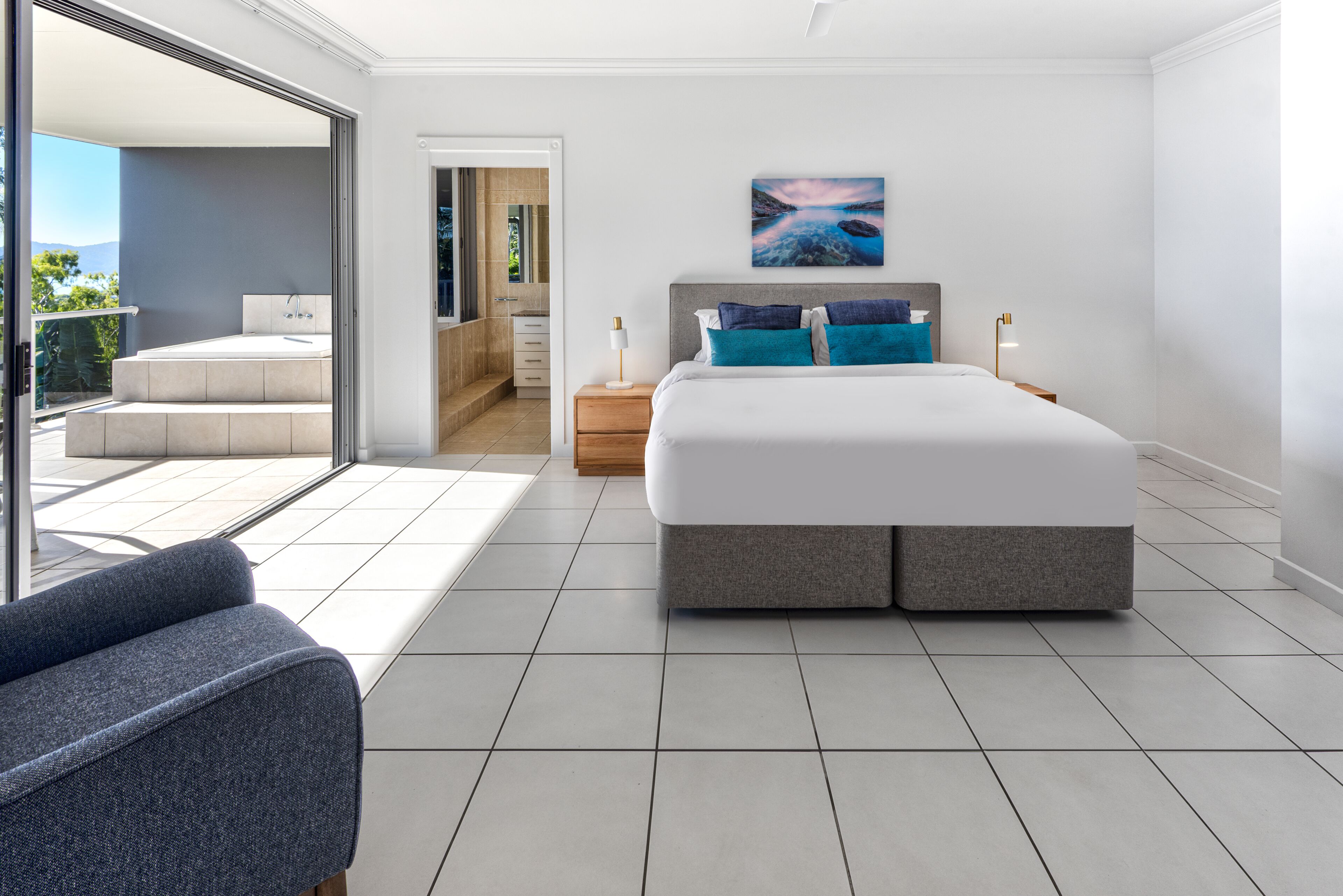 Quarto moderno com cama grande, varanda e vista para o exterior.