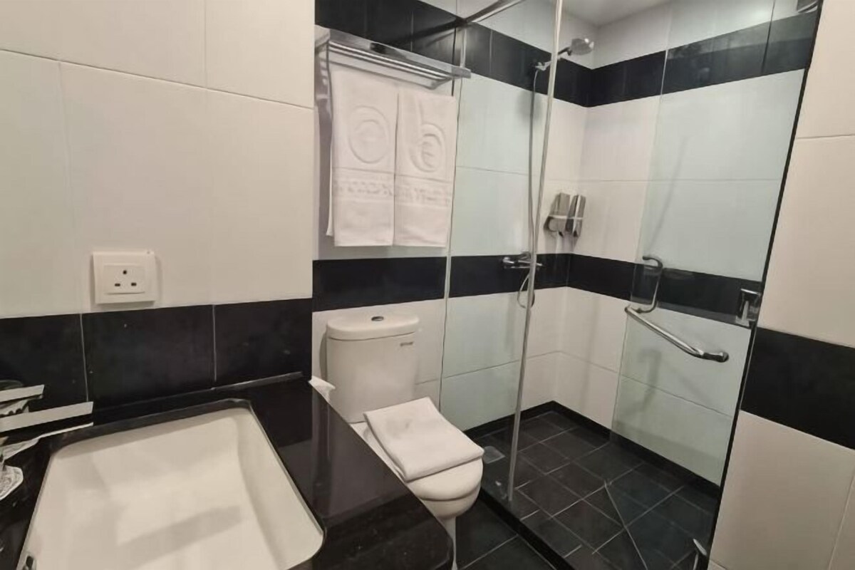 Un baño con bañera, inodoro y zona de ducha.