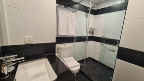A bathroom with a bathtub, toilet, and glass-enclosed shower area. - d'primahotel Bintan (Bintan)
