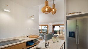 Une cuisine moderne dotée d’une cuisinière intégrée, d’un grand réfrigérateur et d’un coin repas offrant une vue agréable.
