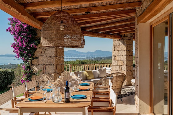 Mesa de madera lista para comer, con vistas a las montañas y al mar.