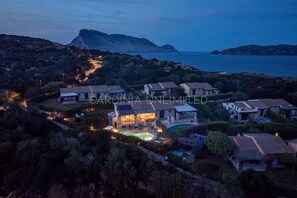 A coastal residential area with multiple houses, a swimming pool, and a mountainous backdrop. - Villa Flor de Lis: Private swimming pool in Punta Molara, 600 meters from the beach. SARDINIA UN... (Isola Molara)
